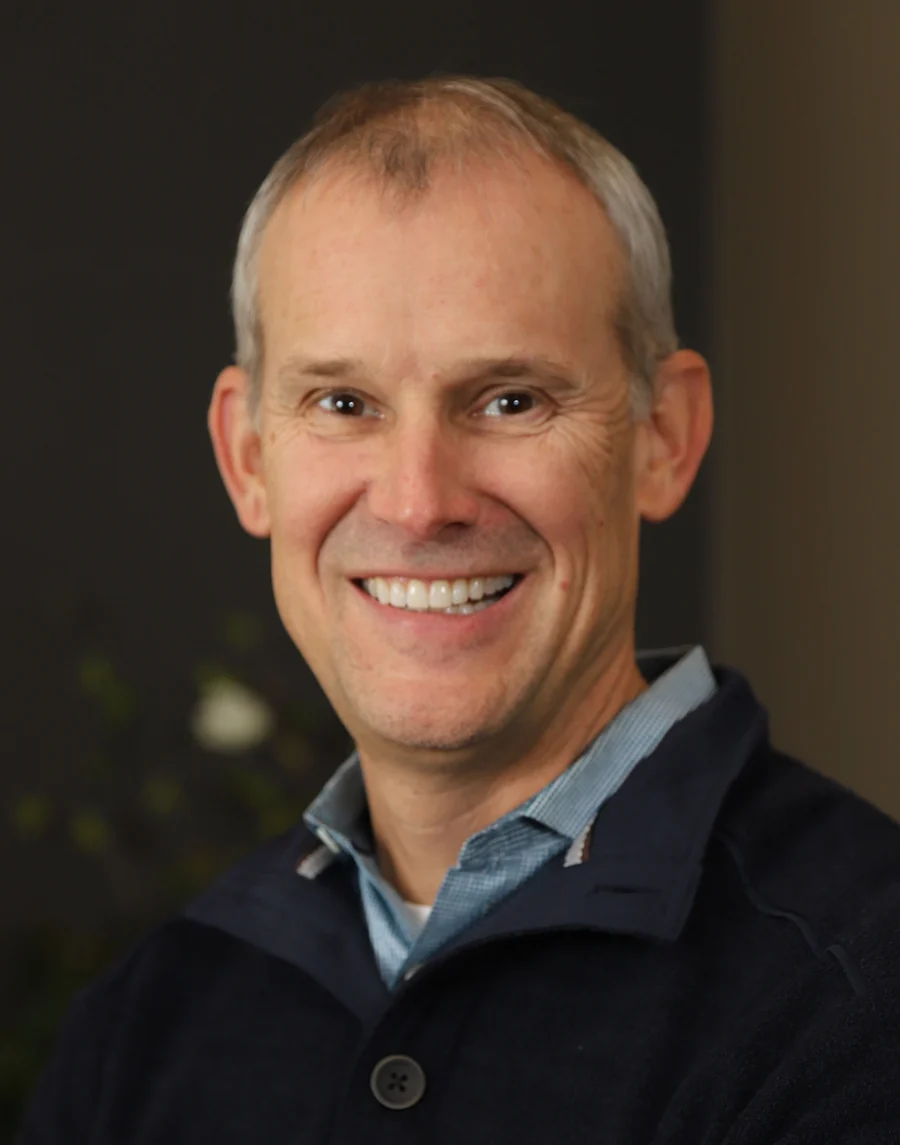 Dr. Byron J. Nordhus, DDS, smiling, in a navy sweater and collared shirt.