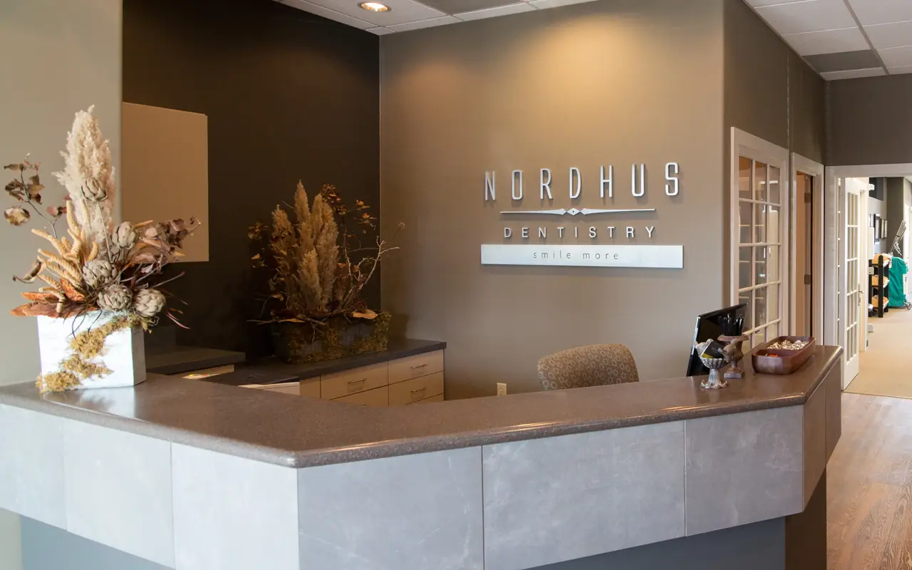 The reception desk and lobby at Nordhus Dentistry, with the NORDHUS DENTISTRY sign on the wall behind it.