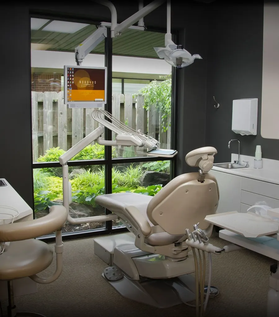 A Nordhus Dentistry treatment room, its window facing a garden.