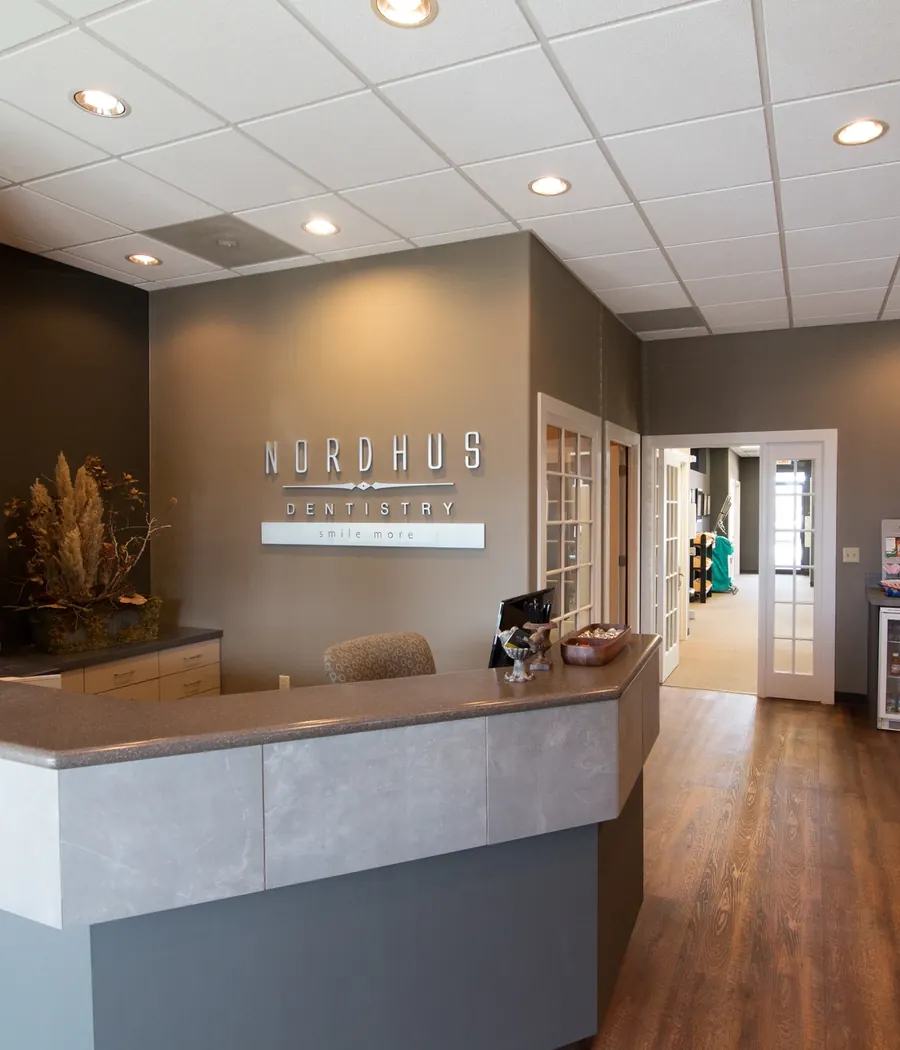 The Nordhus Dentistry reception desk and lobby, with a coffee and beverage station at the back.