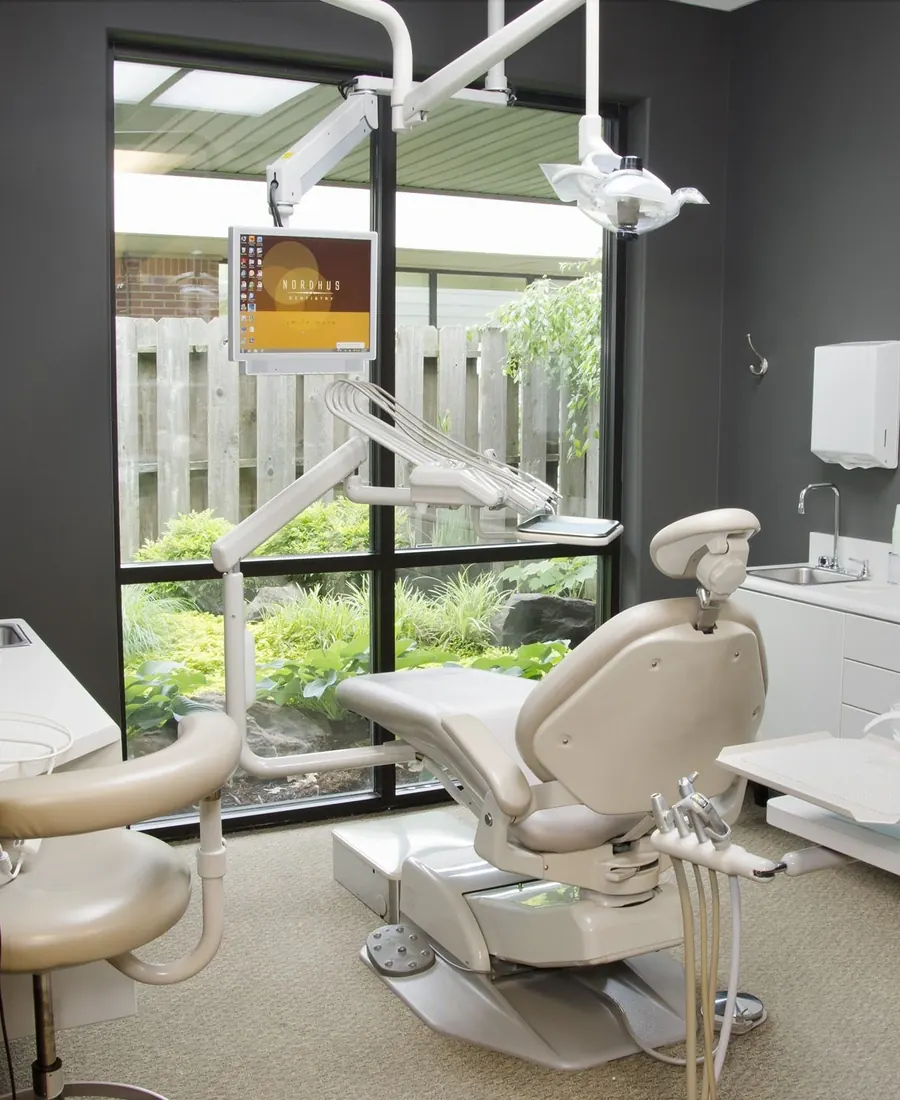 A treatment room at Nordhus Dentistry, its window looking onto a planted garden.